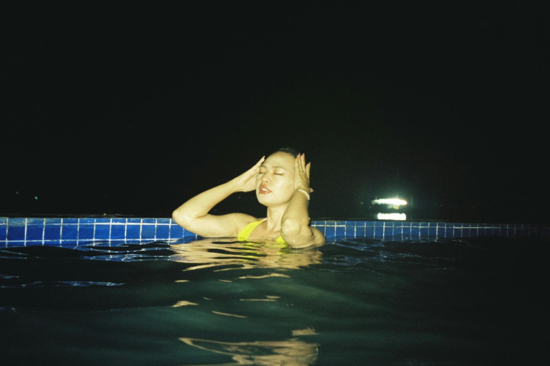 Kobieta relaksuje się nocą w basenie, jak w hotelowym SPA