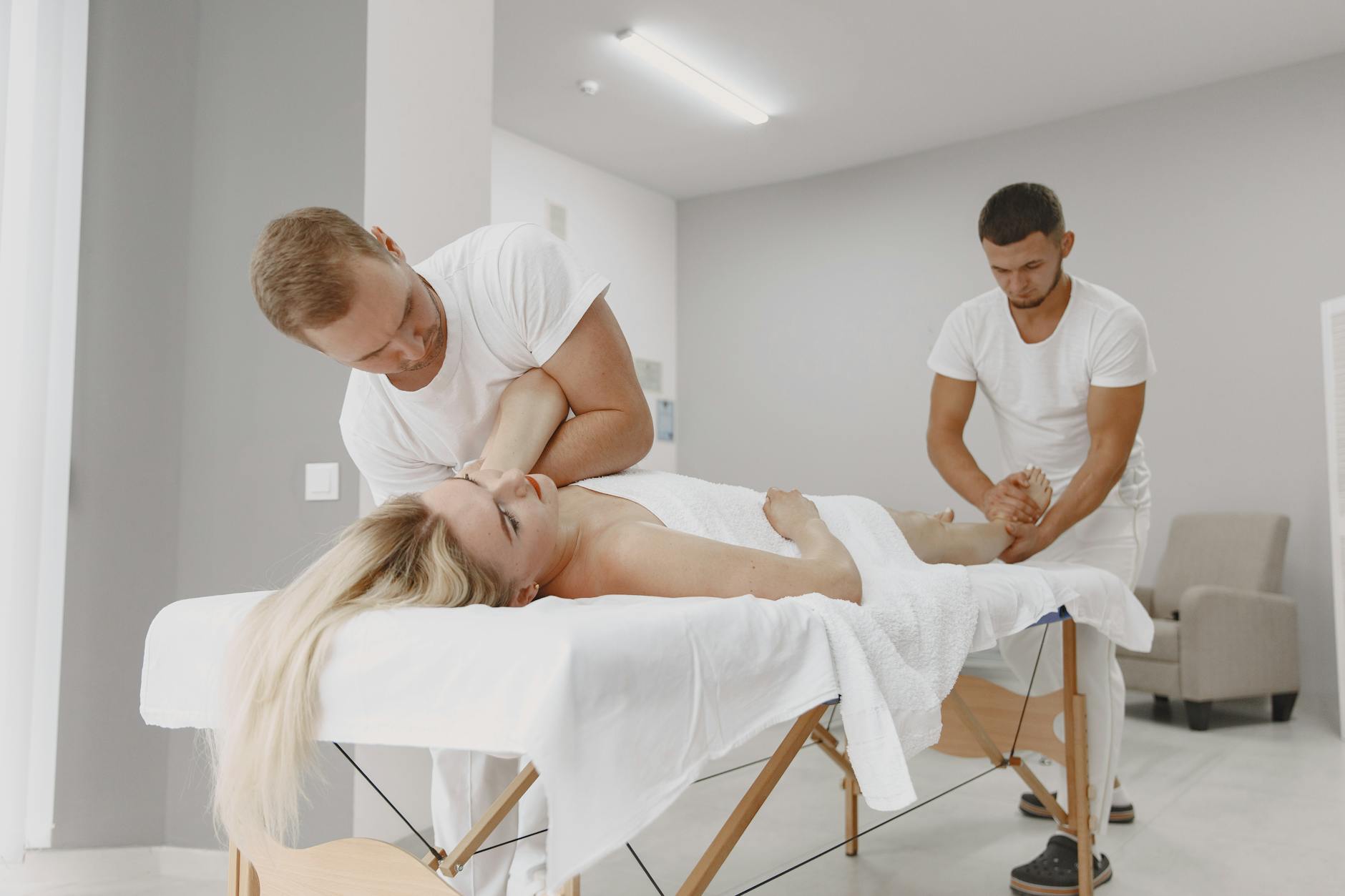 Kobieta masowana jednocześnie przez dwie osoby w nowoczesnym spa