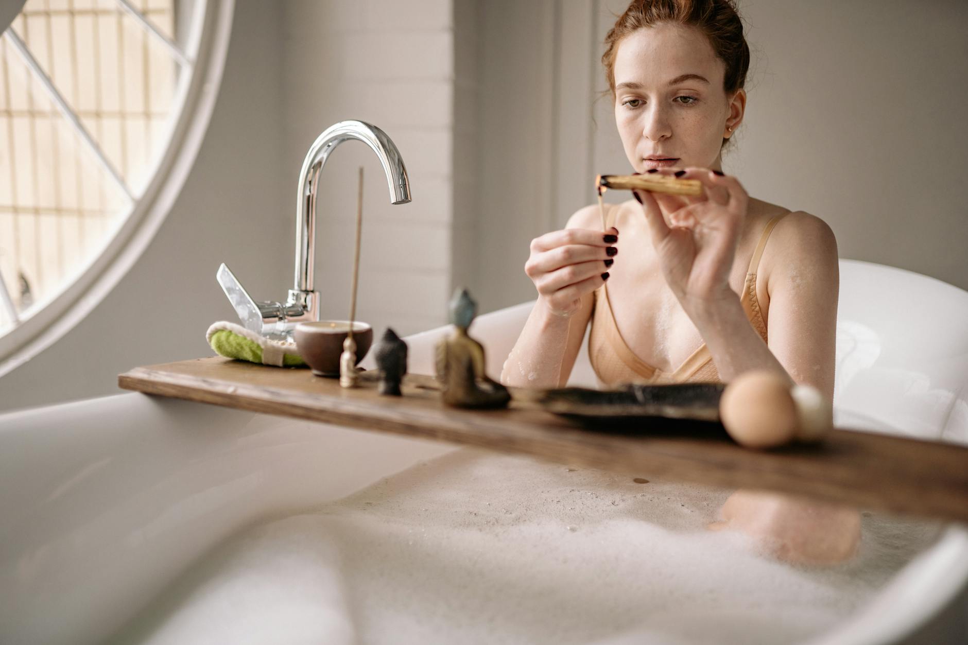 Kobieta w wannie relaksuje się z aromaterapią palo santo