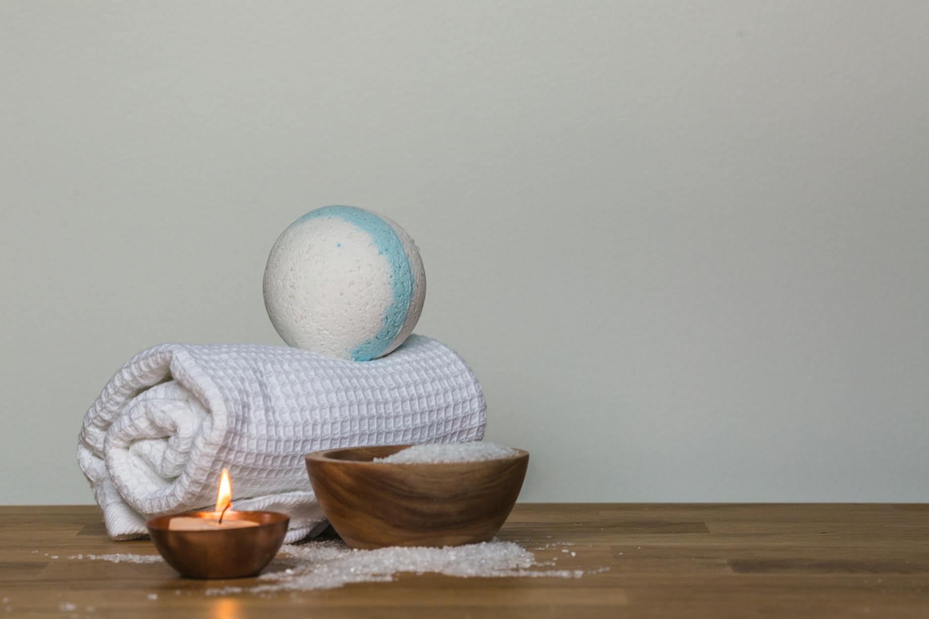 Relaksacyjna aranżacja domowego spa z kulą do kąpieli, solą i świecą