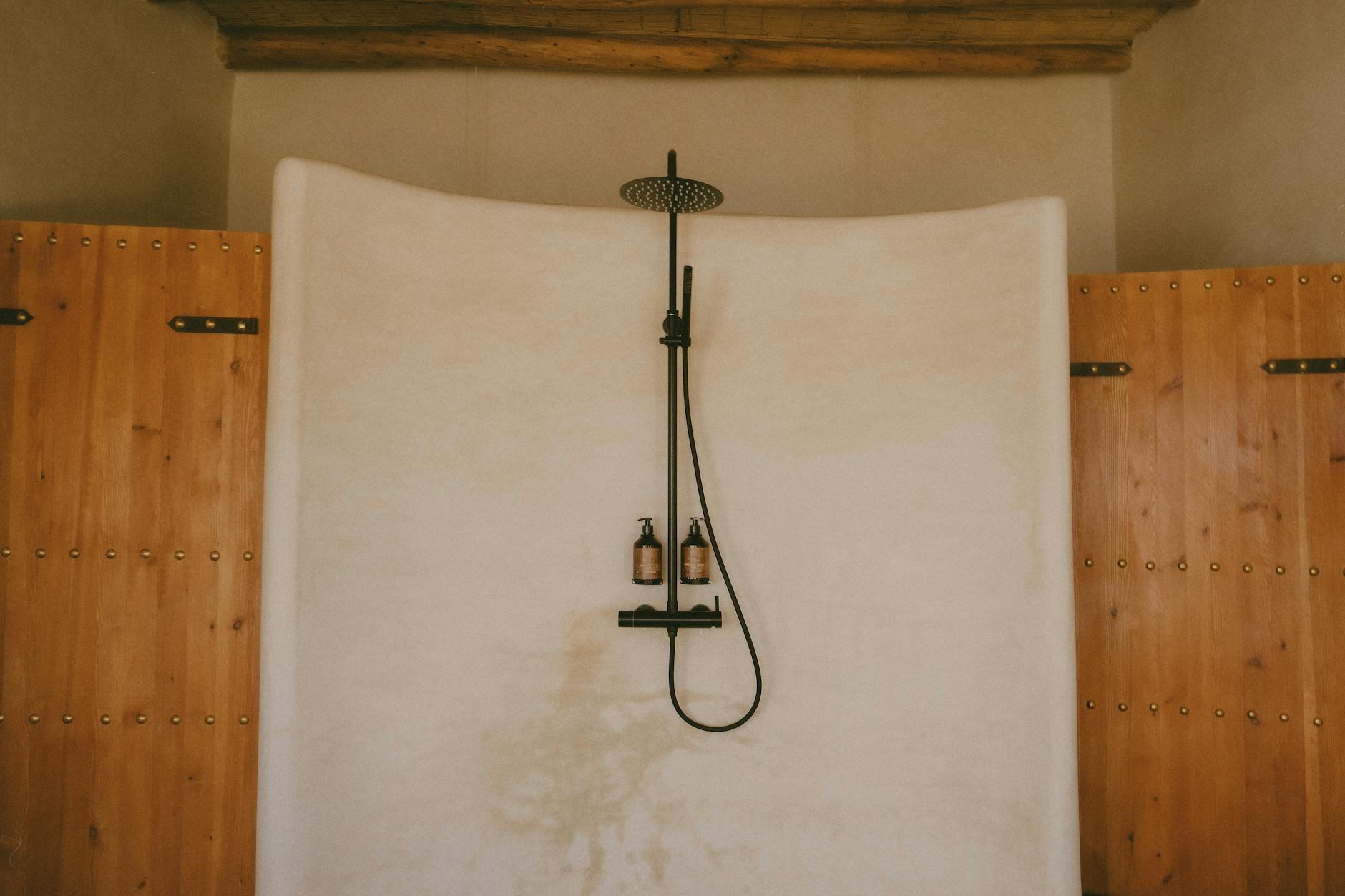 Rustyczny prysznic w tradycyjnej marokańskiej łazience z drewnianymi drzwiami