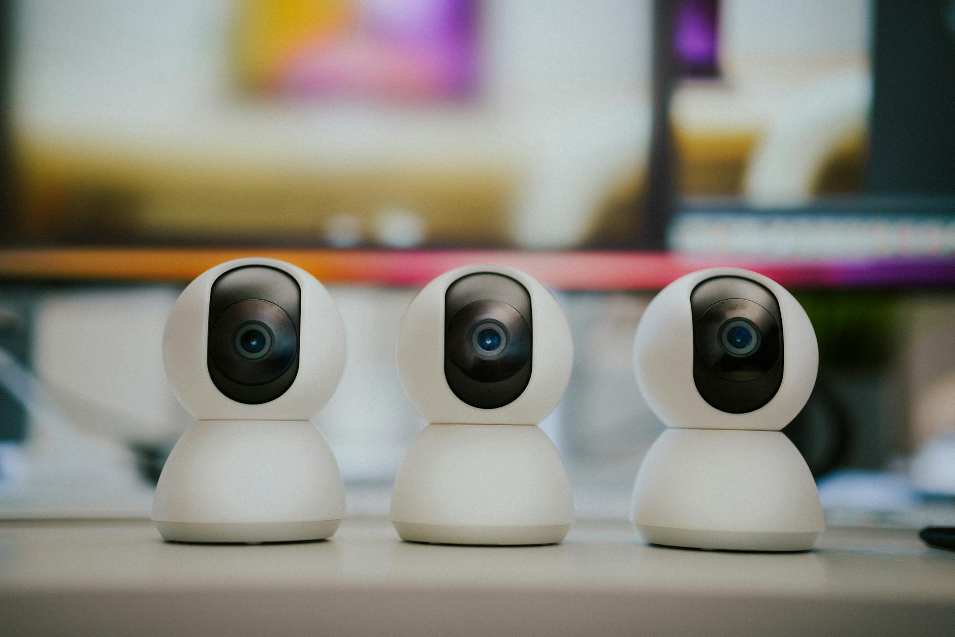 Trzy nowoczesne kamery do domowego monitoringu stojące na stole