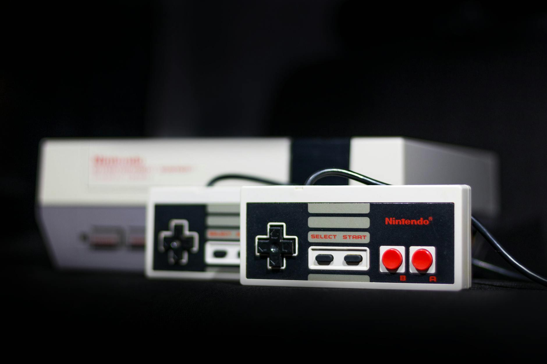 Jak gry komputerowe zmieniały się na przestrzeni dekad: kluczowe etapy rozwoju branży Klasyczna konsola Nintendo z padami jako symbol retro gamingu