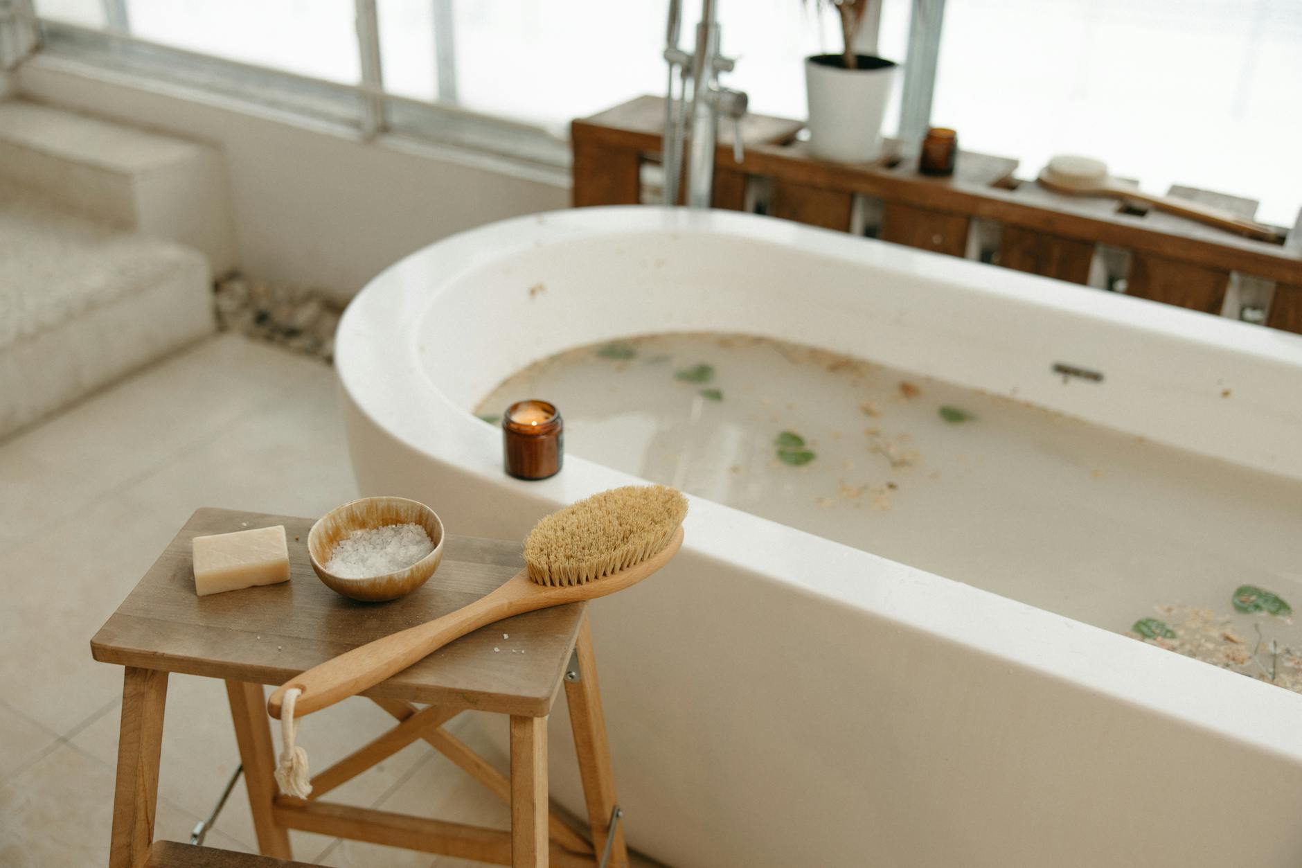 Pachnące sole do kąpieli DIY: trzy warianty na relaks, energię i oczyszczenie Relaksująca kąpiel spa z solą, mydłem, szczotką i zapaloną świecą
