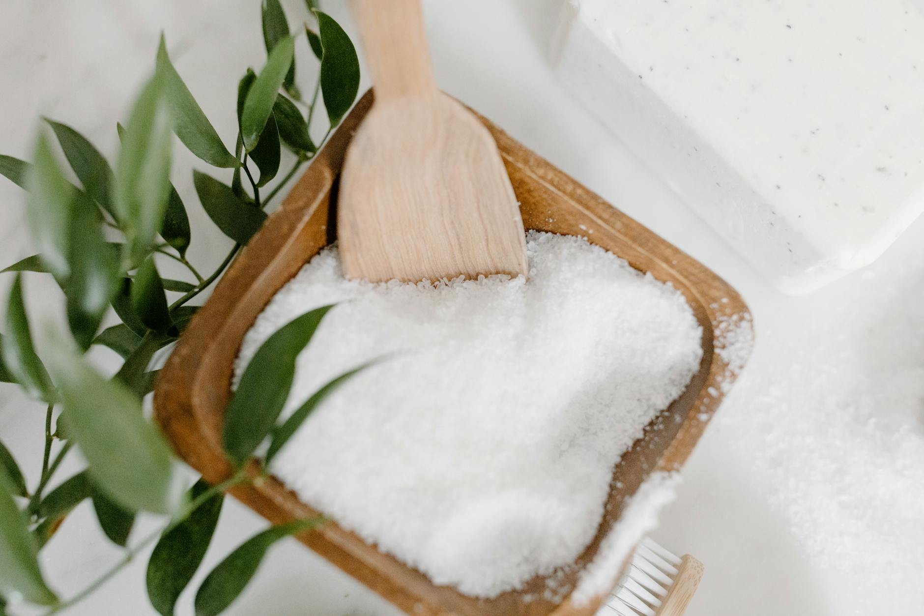 Sól do kąpieli w drewnianej łyżce w otoczeniu naturalnych dodatków