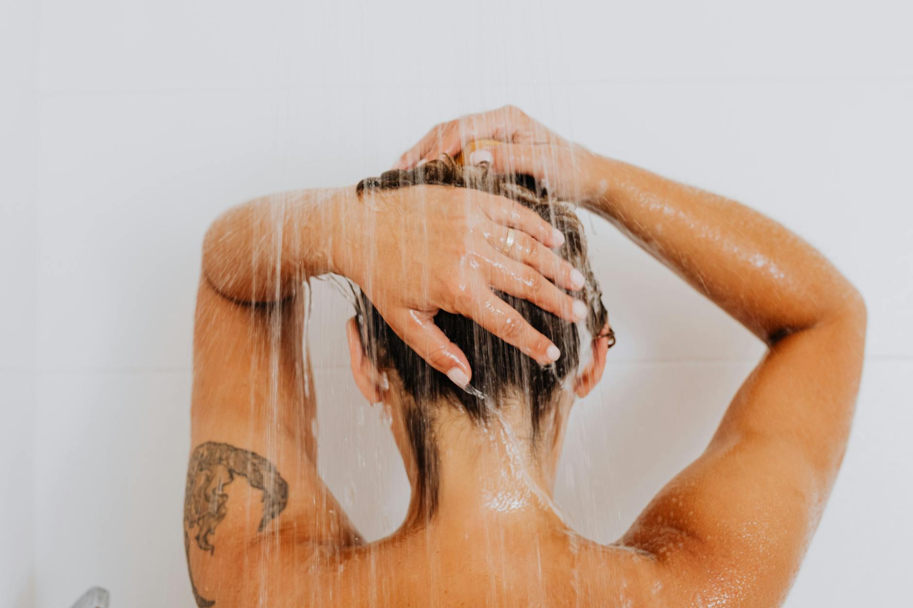 Tatuaż na ręce osoby biorącej relaksujący prysznic spa